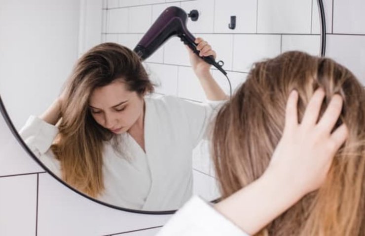 donna asciuga i capelli